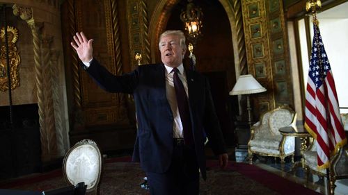 President Donald Trump waves as he leaves the room following his talk with reporters and troops via teleconference from his Mar-a-Lago estate in Palm Beach, Florida.