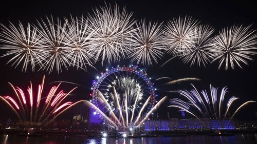 Fireworks explode over the London Eye Ferris wheel by the River Thames in London, to mark the start of the new year, Wednesday, Jan. 1, 2020