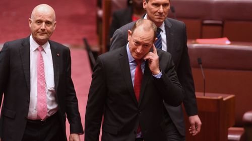 New Queensland Senator Fraser Anning (centre), who replaces former One Nation Senator Malcolm Roberts, arrives to be sworn-in in the Senate chamber (Image: AAP)