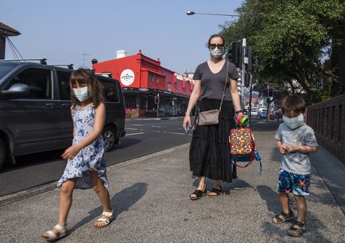 A Sydney mother and her two children wear face masks as they walk near Bondi, in Sydney's east.