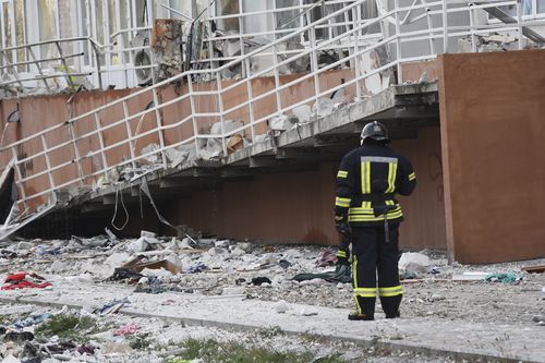 A firefighter stands next to an apartment building damaged by Russian shelling in Odesa, Ukraine.