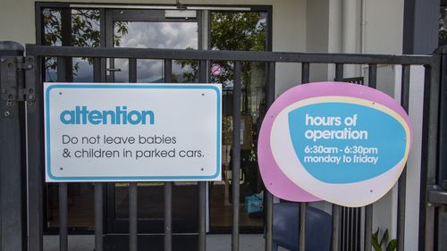 A sign stating Do not leave babies & children in parked cars is seen attached to the front gate of the Goodstart Early Learning Centre.