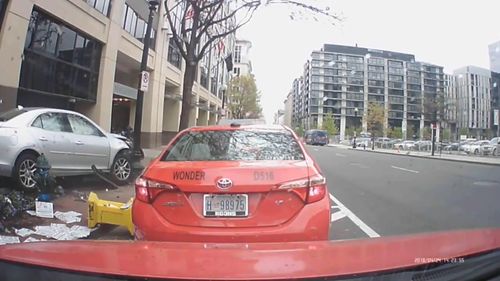 A silver Chevy Malibu soars out of control and onto the curb before hitting a pole. 