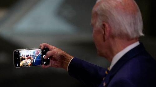 Joe Biden takes a selfie with soldiers at a Thanksgiving dinner.