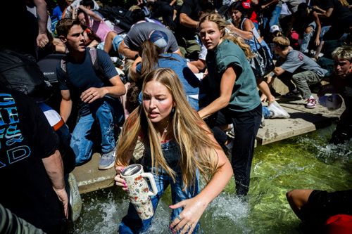 The crowd reacts in fear and shock after Charlie Kirk is shot.