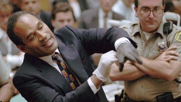 O.J. Simpson grimaces as he tries on one of the leather gloves prosecutors say he wore the night his ex-wife Nicole Brown Simpson and Ron Goldman were murdered, during the Simpson double-murder trial.