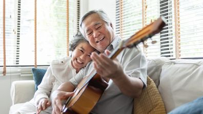 Older couple learning playing guitar instrument