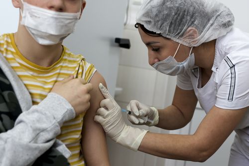A teenager receives a dose of Russia's Sputnik M (Gam-COVID-Vac-M) COVID-19 vaccine in Krasnodar, Russia, Friday, Jan. 28, 2022. This week, Russia started vaccinating children aged 12-17 with a domestically developed shot, Spuntik M  a version of the Sputnik V vaccine that contains a smaller dose  amid reports of a sharp spike of COVID-19 infections and hospitalization in children. (AP Photo/Vitaliy Timkiv)