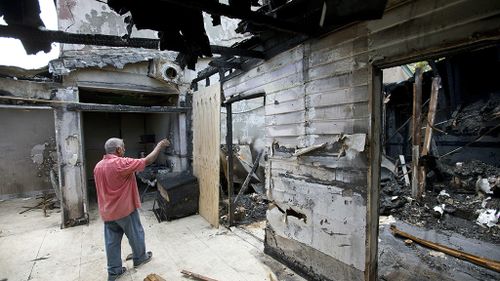 Farhad Khan, who has attended the Islamic Center of Fort Pierce for more than seven years, shows its charred remains. (AAP)