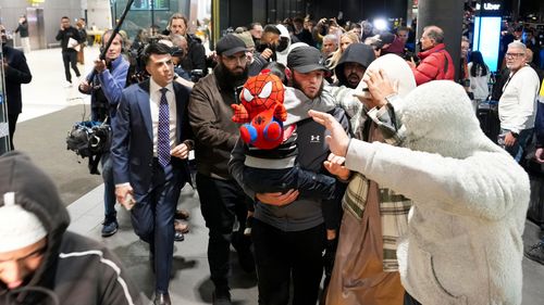 MELBOURNE, AUSTRÁLIA - 07 DE MAIO: Um grupo de apoiadores cerca uma família ligada ao Estado Islâmico quando eles chegam ao aeroporto de Melbourne em 7 de maio de 2026 em Melbourne, Austrália. As mulheres, que viajaram para a Síria para se juntarem ao grupo militante Estado Islâmico, deverão enfrentar interrogatório pela Polícia Federal Australiana à sua chegada, com as autoridades a ponderar possíveis acusações ao abrigo da legislação antiterrorista. (Foto de Asanka Ratnayake/Getty Images)
