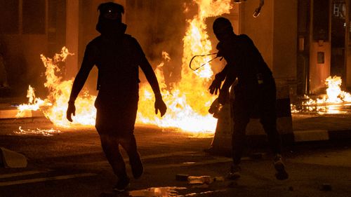 Protesters throw Molotov cocktails at the toll booth for the Cross Harbor Tunnel near the the Hong Kong Polytechnic University campus.