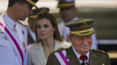 Spanish Crown Prince Felipe, background left, talks with Spanish Princess Letizia, as then Spanish King Juan Carlos, foreground looks on, during a military parade on Armed Forces day in Madrid, Spain (photo: June 8, 2014)