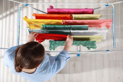 Woman hanging different apparel on clothes airer