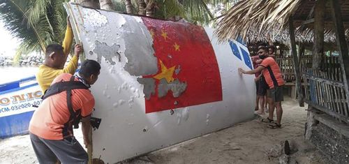 In this handout photo provided by the Philippine Coast Guard, Coast Guard personnel carry debris, which the Philippine Space Agency said has markings of the Long March 5B (CZ-5B) Chinese rocket that was launched on July 24, after it was found in waters off Mamburao, Occidental Mindoro province, Philippines on Aug. 2022. 