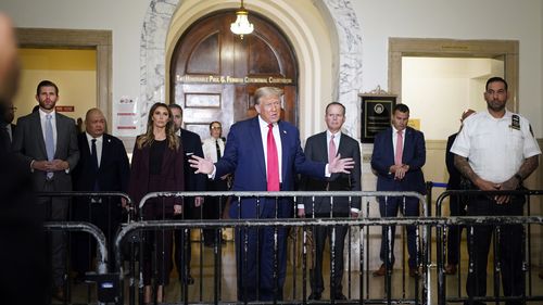 Former President Donald Trump, center, arrives for his civil business fraud trial at New York Supreme Court, Tuesday, Oct. 17, 2023, in New York. Trump's son, Eric Trump, stands at left.