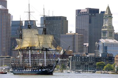 In this Aug. 29, 2014, file photo, the USS Constitution, with its topsails unfurled, is towed through Boston Harbor past Boston's financial district skyline.