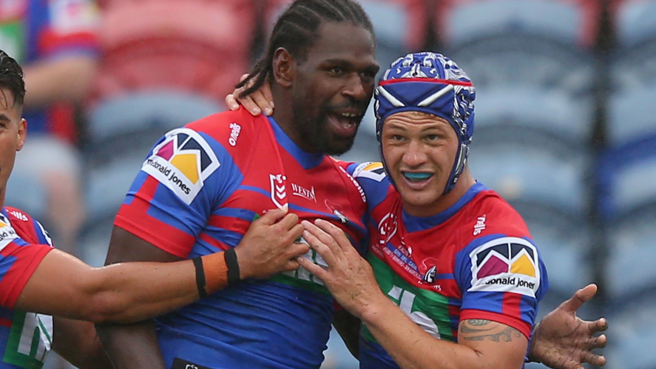 Edrick Lee of the Knights celebrates a try with Kalyn Ponga.