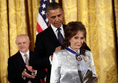 President Barack Obama awards the Presidential Medal of Freedom to Loretta Lynn in 2013 in Washington, DC. 