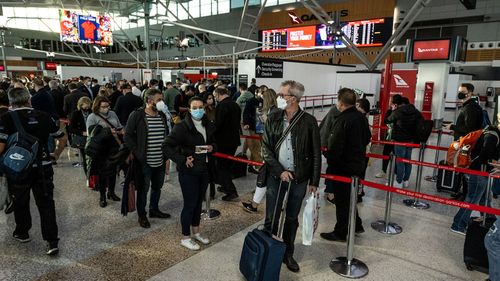 Qantas passengers queue at security check-in at Sydney Airport