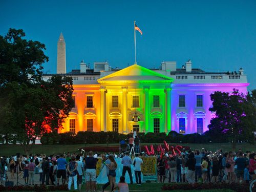 Les gens se rassemblent dans le parc Lafayette de Washington pour voir la Maison Blanche illuminée aux couleurs de l'arc-en-ciel