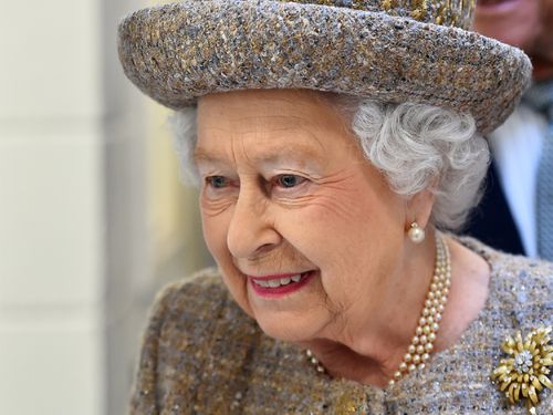 Britain's Queen Elizabeth II looks around a kennel block during a visit to Battersea Dogs and Cats Home in London on March 17, 2015. AFP PHOTO / POOL / BEN STANSALL