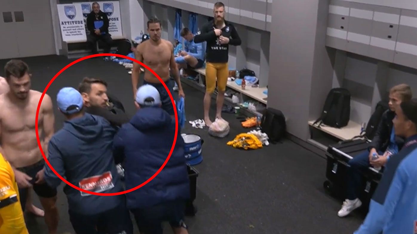 Sydney FC staffers pushed Wanderers midfielder Milos Ninkovic away towards the exit of the dressing room