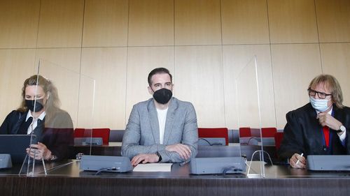 Former soccer player Christoph Metzelder, center, looks on next to his lawyers Julia Donnepp, left, and Ulrich Sommer before the beginning of his trial, at a regional court in Duesseldorf, Germany, Thursday, April 29, 2021. The former defender of Borussia Dortmund, Real Madrid and Schalke 04 stands trial on charges of possession and distribution of child pornography. 