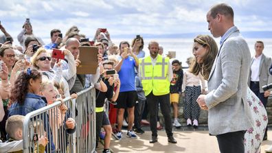 Britain's Prince William and Kate, the Duchess of Cambridge talk with members of the public in Barry Island, Wales, Wednesday Aug. 5, 2020, during their visit to speak to local business owners about the impact of COVID-19.