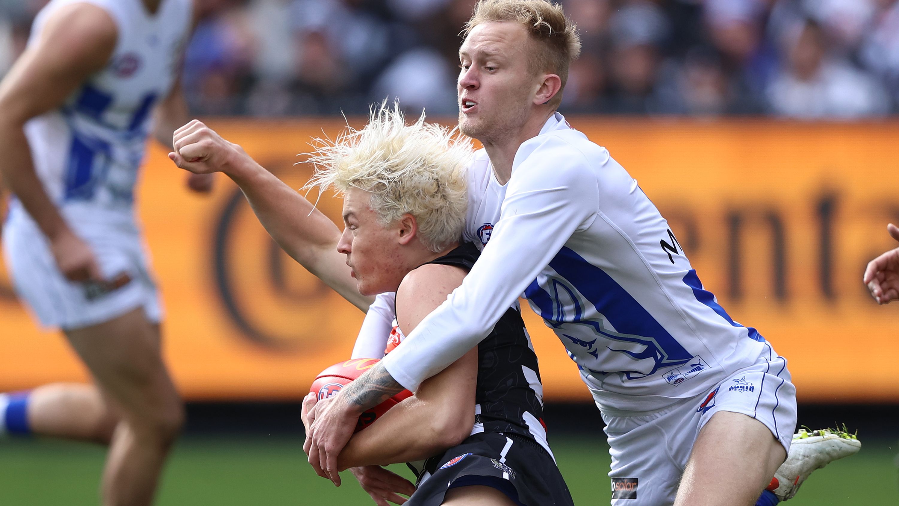 Jack Ginnivan of the Magpies is challenged by Jaidyn Stephenson of the Kangaroos.