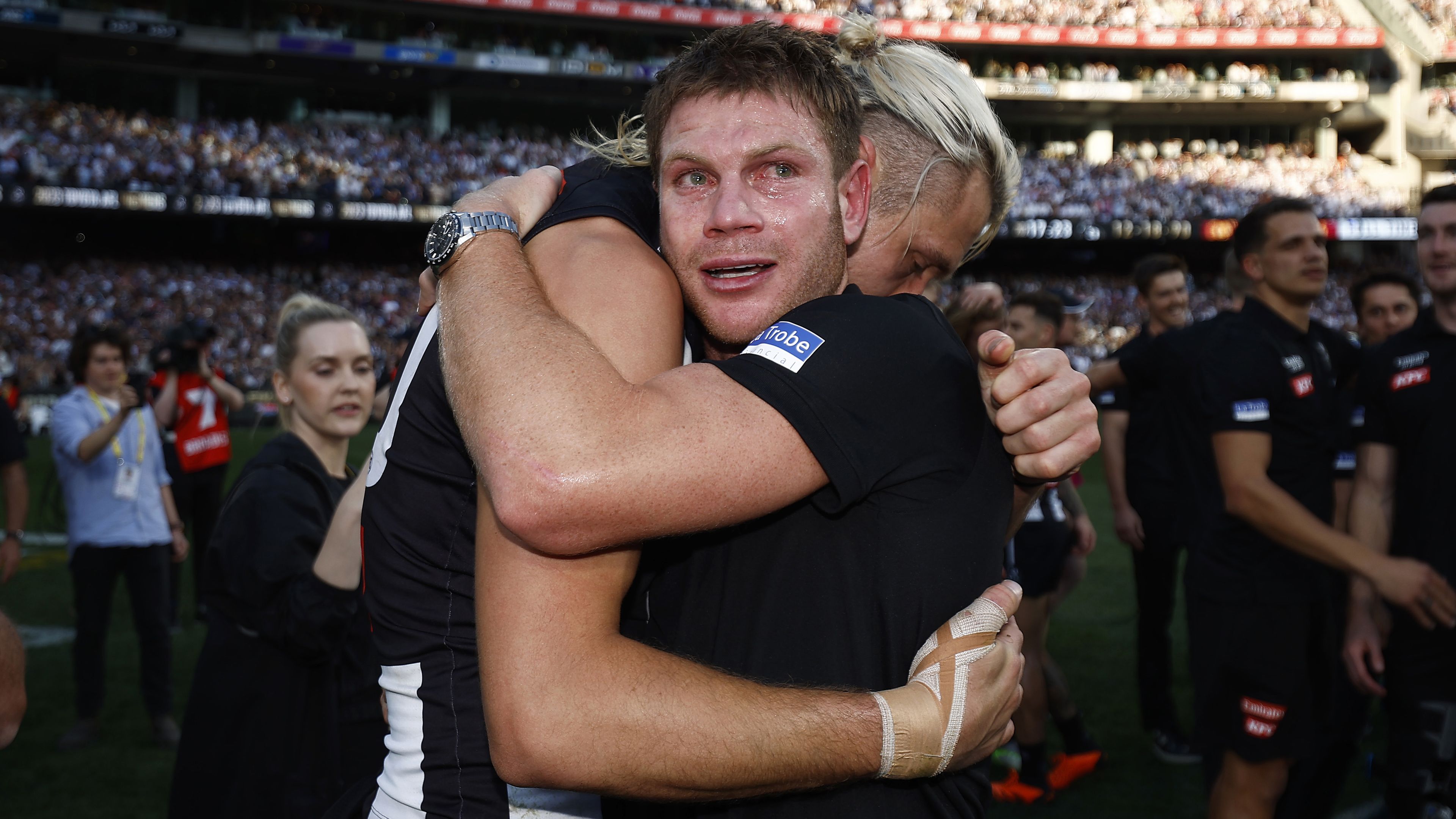 MELBOURNE, AUSTRALIA - SEPTEMBER 30: An emotional Taylor Adams of the Magpies hugs Darcy Moore of the Magpies after the 2023 AFL Grand Final match between Collingwood Magpies and Brisbane Lions at Melbourne Cricket Ground, on September 30, 2023, in Melbourne, Australia. (Photo by Daniel Pockett/AFL Photos/via Getty Images)