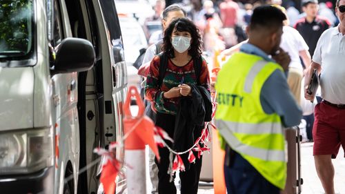 A woman wearing a face mask seen near the Overseas Passenger Terminal where the Norwegian Jewel cruise ship is moored at Circular Quay in Sydney, Friday, February 14, 2020. 
