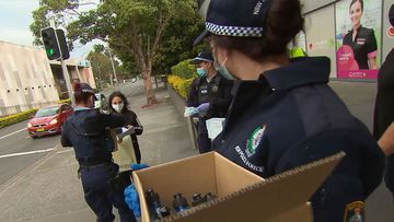Police in Sydney handing out PPE gear.