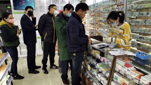 People line up to buy face masks at a pharmacy in Shanghai, Monday, Jan. 27, 2020.