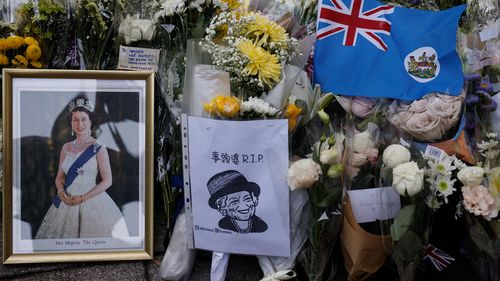 Colonial flag of Hong Kong and images of Britain's Queen Elizabeth are placed outside the British Consulate-General, after she died aged 96, in Hong Kong, China September 12, 2022. REUTERS/Tyrone Siu