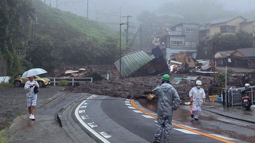 In this photo taken and provided by Satoru Watanabe, a road is covered by mud and debris following heavy rain in Atami city, Shizuoka prefecture, Saturday, July 3, 2021.