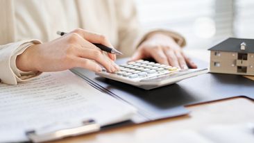 Woman budgeting with calculator and bills