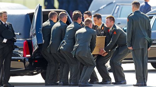 Dutch military personnel load a numbered coffin, contraining an unidentified body from the crash of MH17, into its own hearse at Eindhoven airport. (Getty)