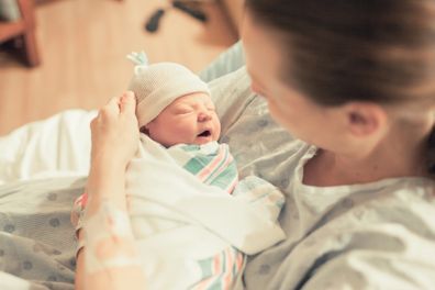 Mother holding her newborn baby after labor in the hospital.