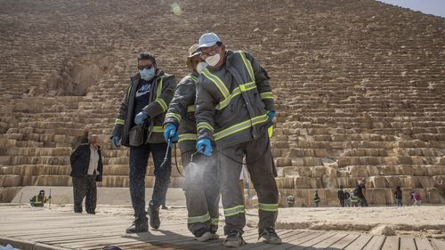 Municipal workers sanitize the Giza Pyramids as prevention measures due to the coronavirus outbreak, in Egypt, Wednesday, March 25, 2020.