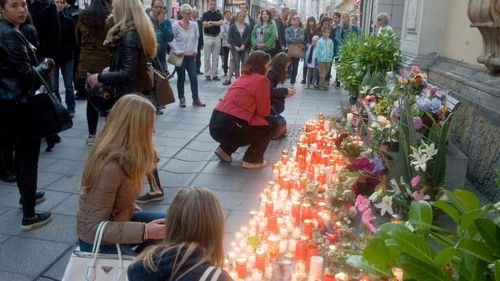 Crowds gathered at the Grazer Stadtpfarrkirche church to leave candles and messages for the victims. (AAP)