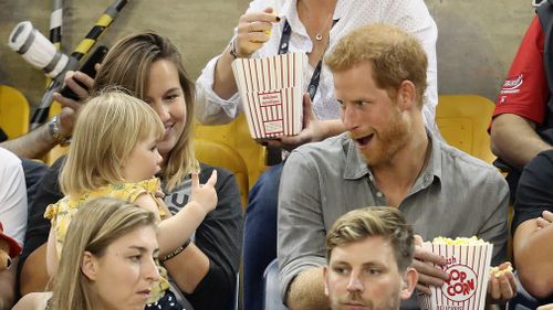 Hayley Henson and daughter Emily Henson sit with Prince Harry at the Sitting Volleyball Finals during the Invictus Games 2017. (AFP)