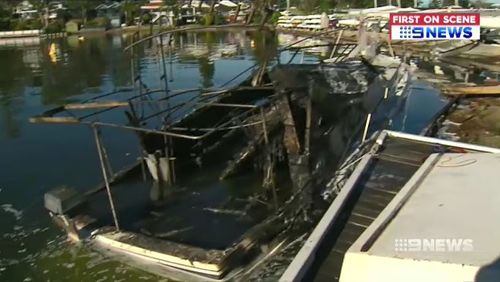 The boat's charred wreckage remains moored at the yacht club. Picture: 9NEWS.