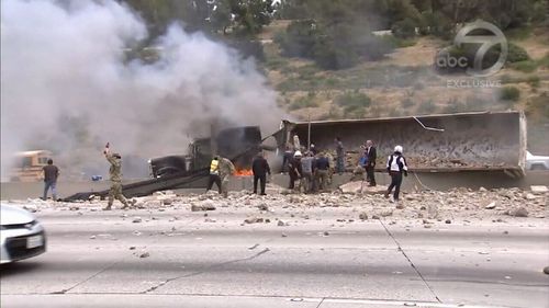 A truck carrying cement collided with a sedan and overturned on the 405 freeway (9NEWS)