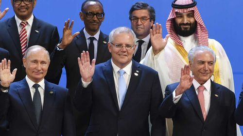 Scott Morrison waves to the camera next to Russian President Vladimir Putin and Saudi Crown Prince Mohammed Bin Salman.