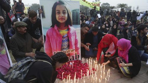 Pakistani students light candles during a protest rally to condemn the rape and killing of Zainab Ansari. (AAP)