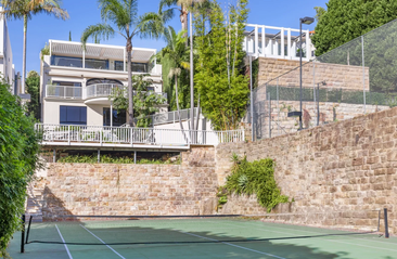 Backyard view of a tennis court and trophy home of 57 Bundarra Road, Bellevue Hill.