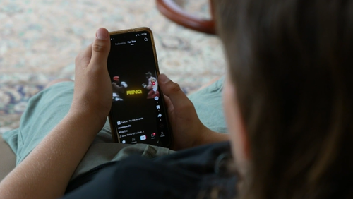 Children using social media on a smart phone.