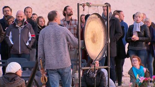 The crowd paid silent tribute to the 40-year-old, before striking a gong. (9NEWS)