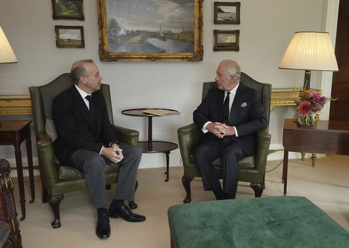 Britain's King Charles III during an audience with Northern Ireland Secretary Chris Heaton-Harris, left, at Hillsborough Castle, Belfast, Tuesday Sept. 13, 2022. King Charles III and Camilla, the Queen Consort, flew to Belfast from Edinburgh on Tuesday, the same day the queens coffin will be flown to London from Scotland. (Niall Carson/Pool via AP)