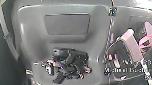 This image from a May 17, 2015 police video shows the weapons are piled up in the backseat of Waco Police SWAT officer Michael Butcher while he was investigate a shooting between two rival biker gangs at Twin Peaks restaurant in Waco, Texas (Waco Police via AP)